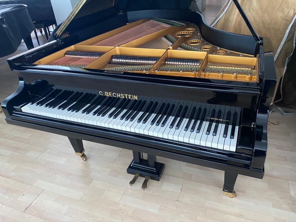 Ein schwarzer Flügel steht auf einem Holzboden