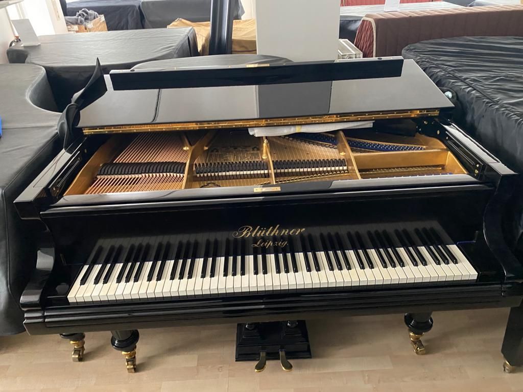 Ein schwarzer Flügel steht auf einem Holzboden