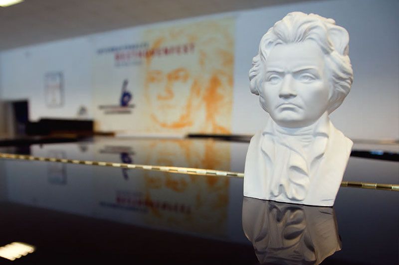 Eine Statue von Beethoven sitzt auf einem Klavier