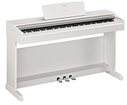 Auf einem weißen Tisch steht ein weißes Digitalpiano.