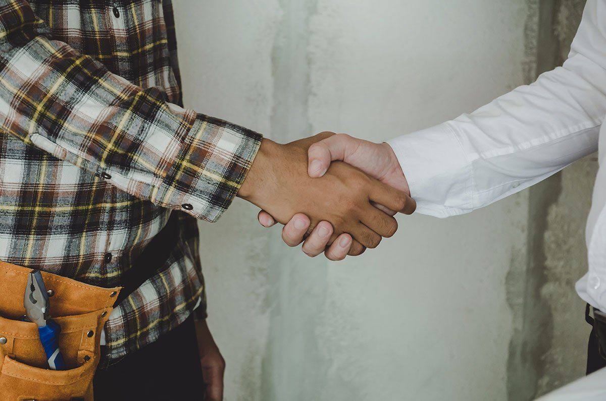 Artisan et son client qui se serrent la main.