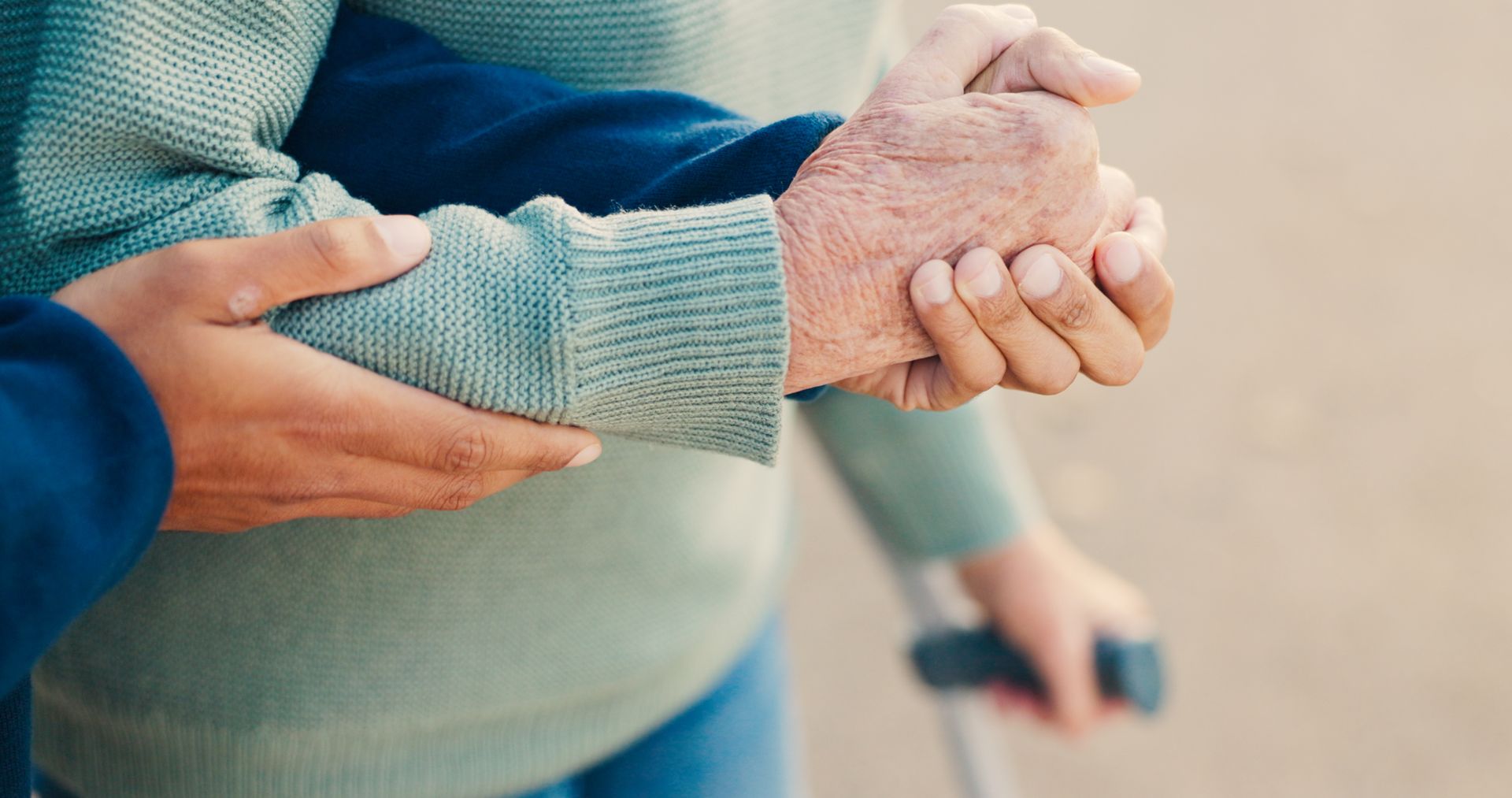 Une main soutient le bras d'une personne âgée