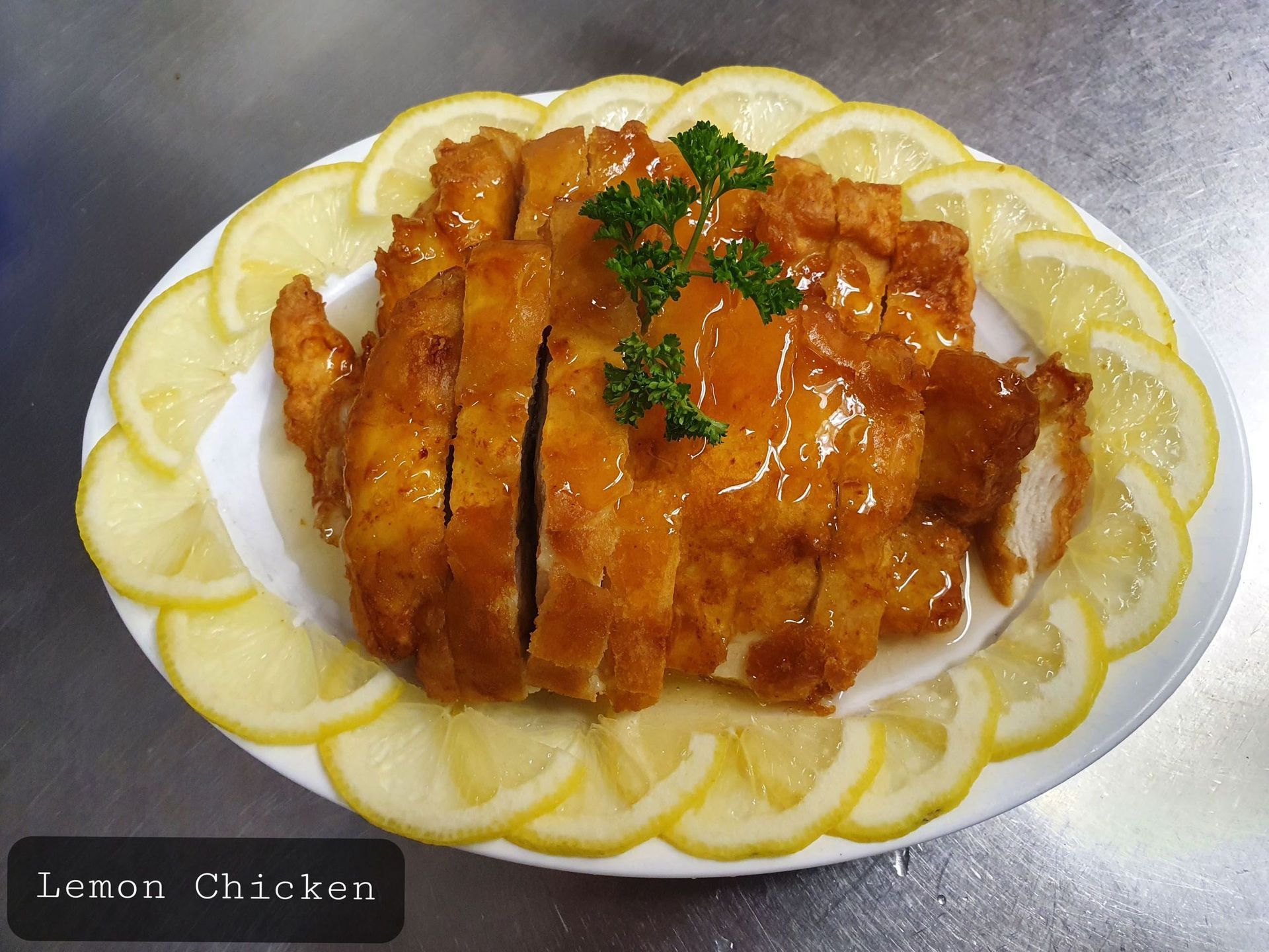 Ein Teller Zitronenhähnchen mit Zitronenscheiben drumherum