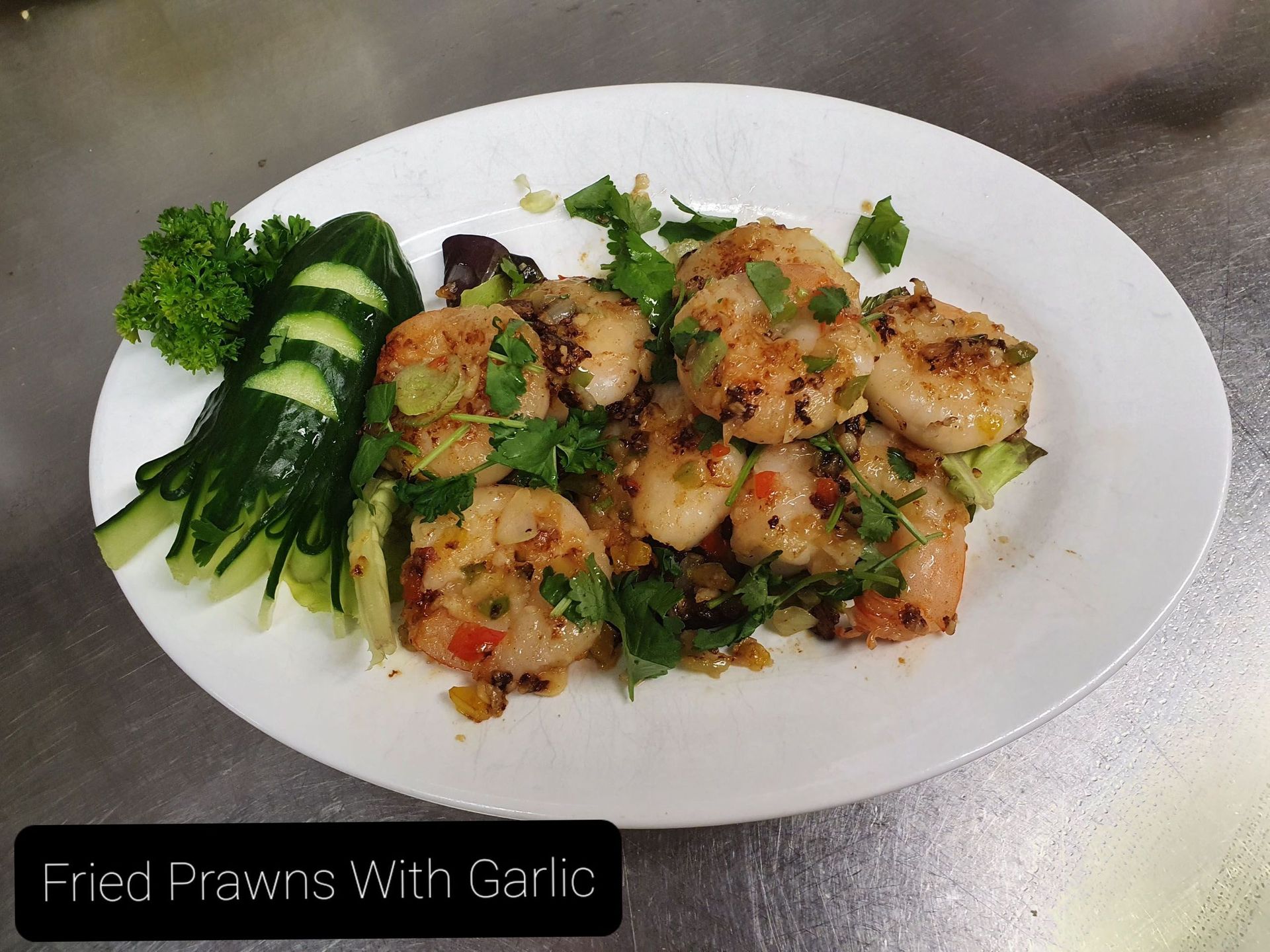 Ein Teller mit gebratenen Garnelen mit Knoblauch und Gurke