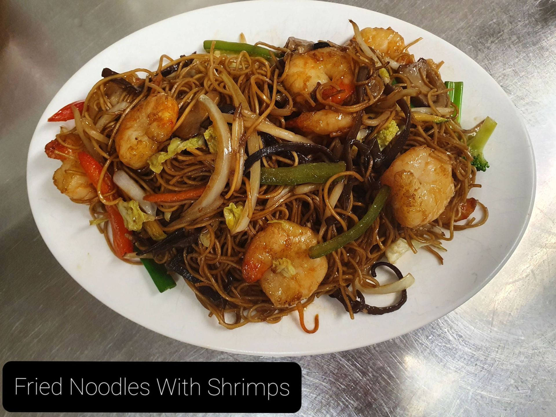 Gebratene Nudeln mit Garnelen auf einem weißen Teller
