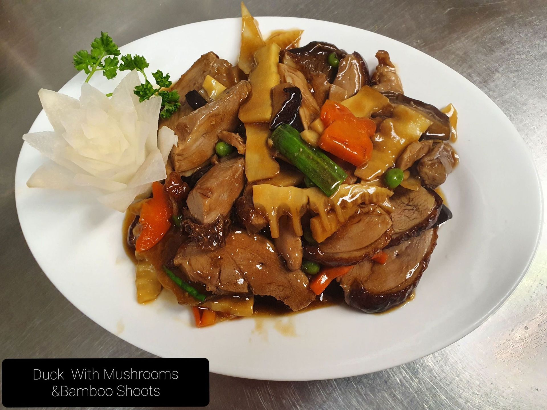 Ein weißer Teller mit Ente mit Pilzen und Karotten