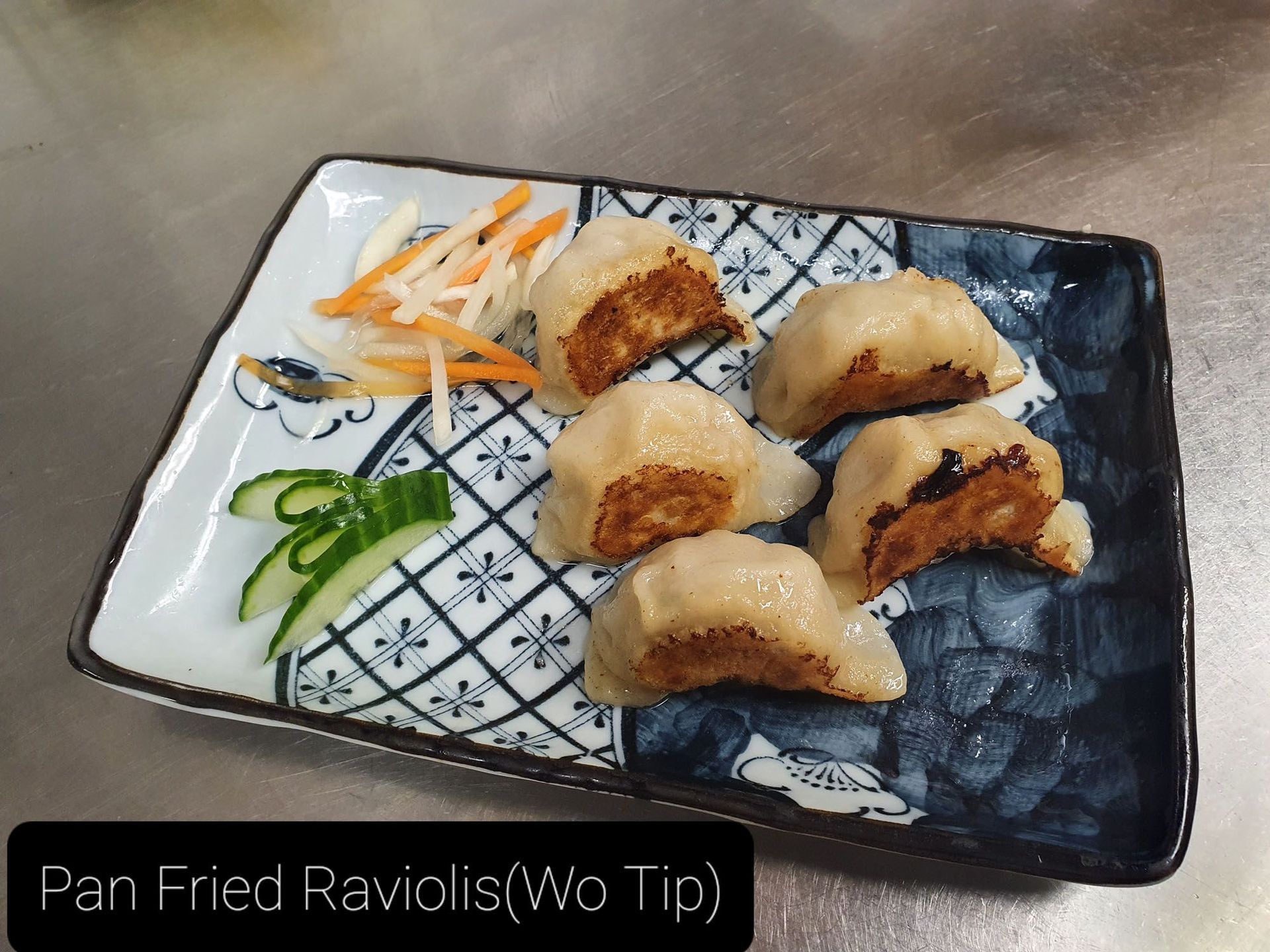 Ein Teller mit gebratenen Ravioli mit Gemüse auf einem Tisch