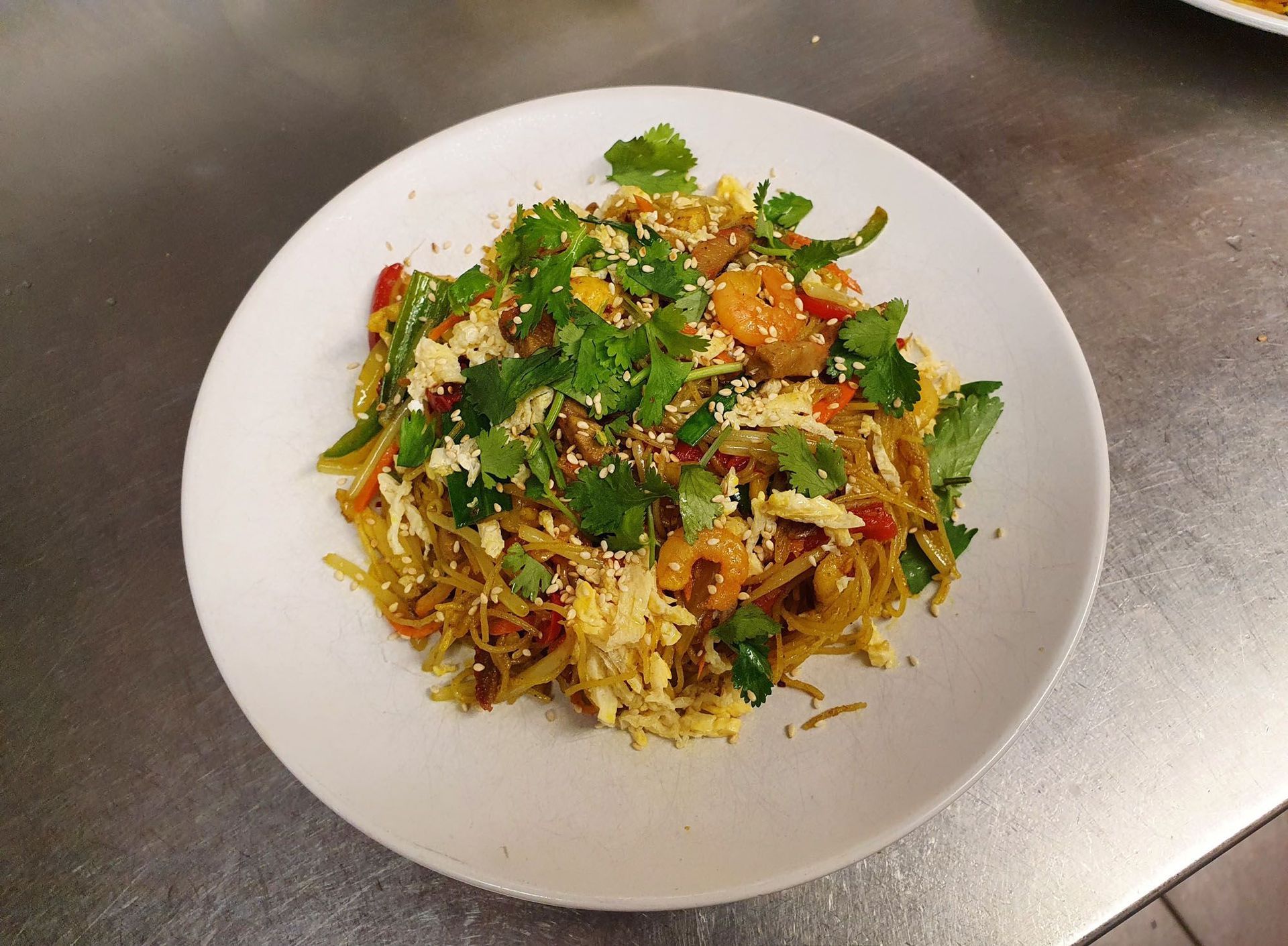 Ein Teller mit Nudeln und Gemüse auf einem Tisch.