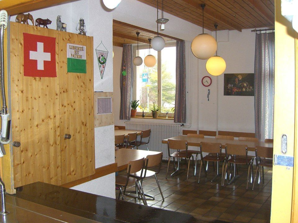 Une pièce avec des tables en bois, des chaises, des lampes suspendues en forme de globe.