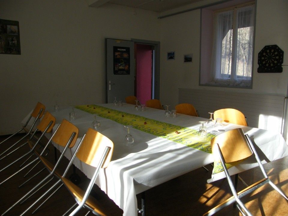 Une table de conférence avec un chemin de table jaune et des chaises dans une pièce épurée.