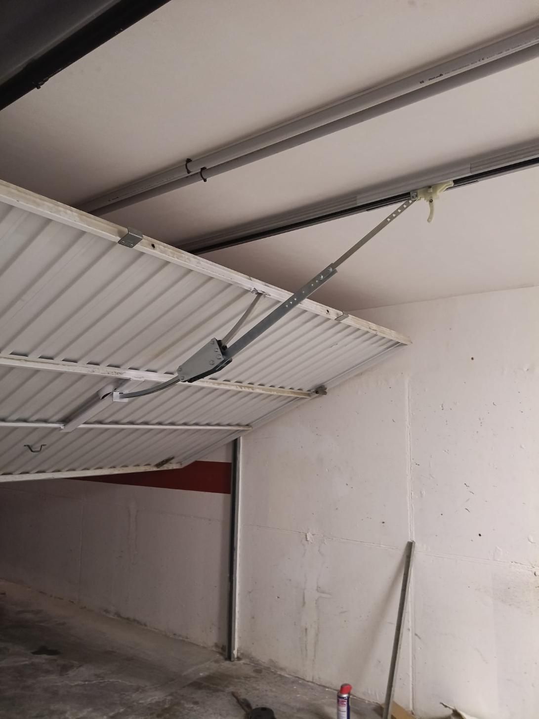 Techo y puerta de garaje, construcción metálica, puerta parcialmente abierta, abridor eléctrico visible.