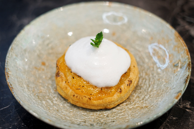 Un primer plano de un postre en un plato sobre una mesa.