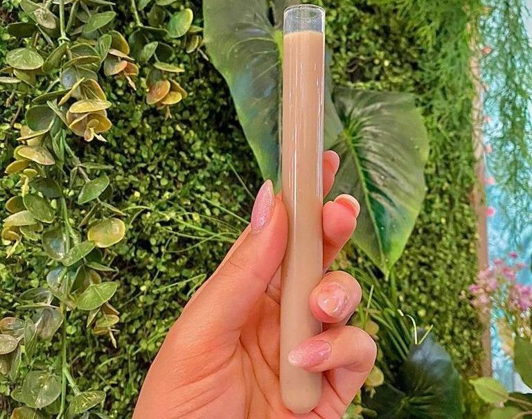 Una persona sostiene un tubo de líquido en su mano.