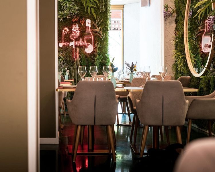 Un restaurante con mesas y sillas y una pared verde.