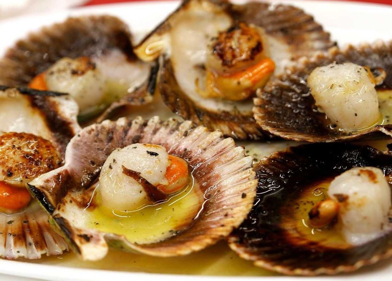 Un primer plano de un plato de vieiras sobre una mesa.