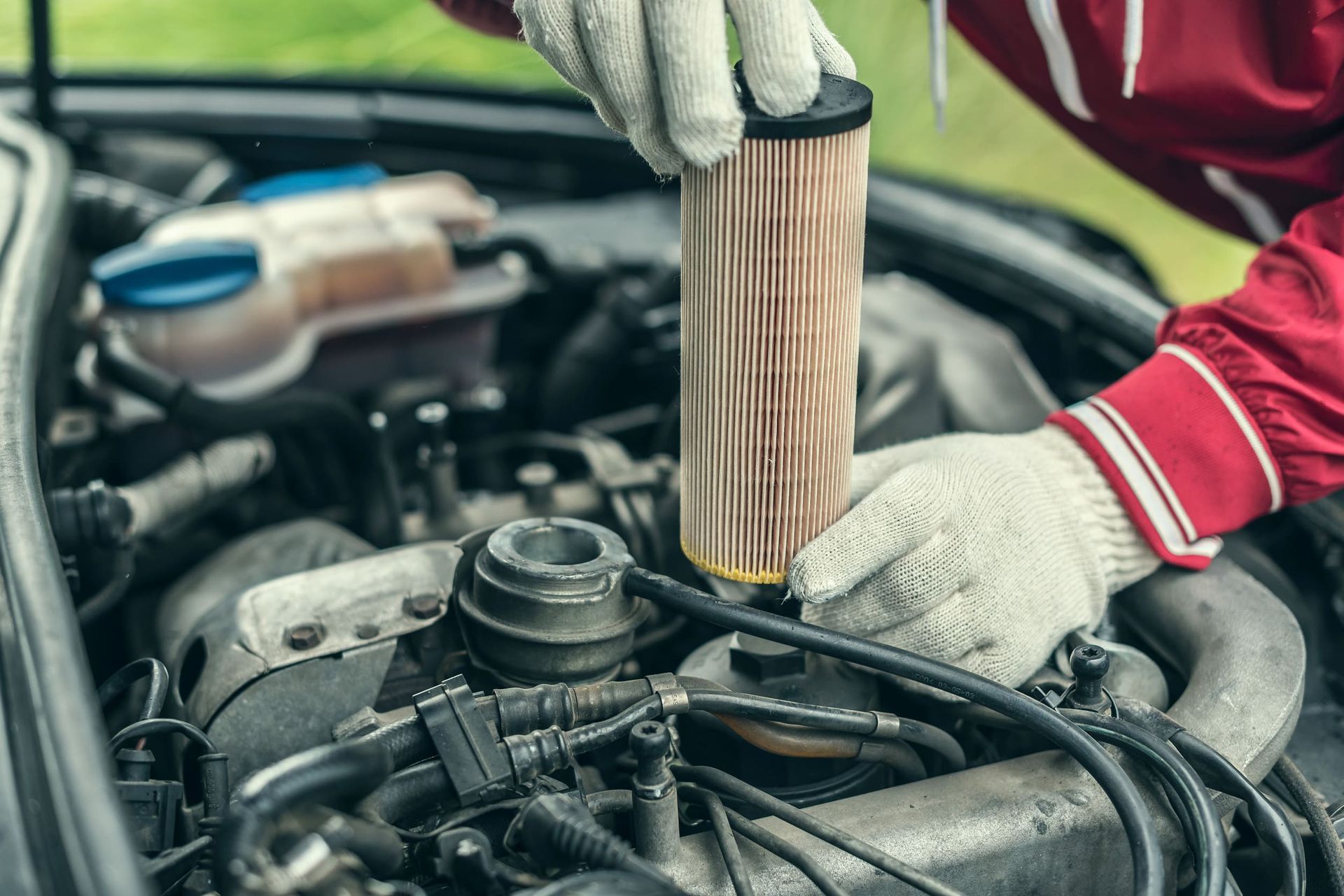 Una persona está cambiando el filtro de aceite en el motor de un automóvil.