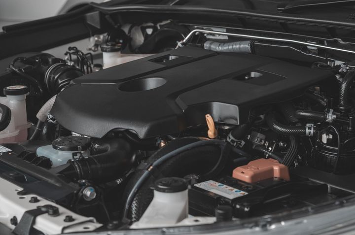 Un primer plano de un motor de automóvil con el capó abierto.