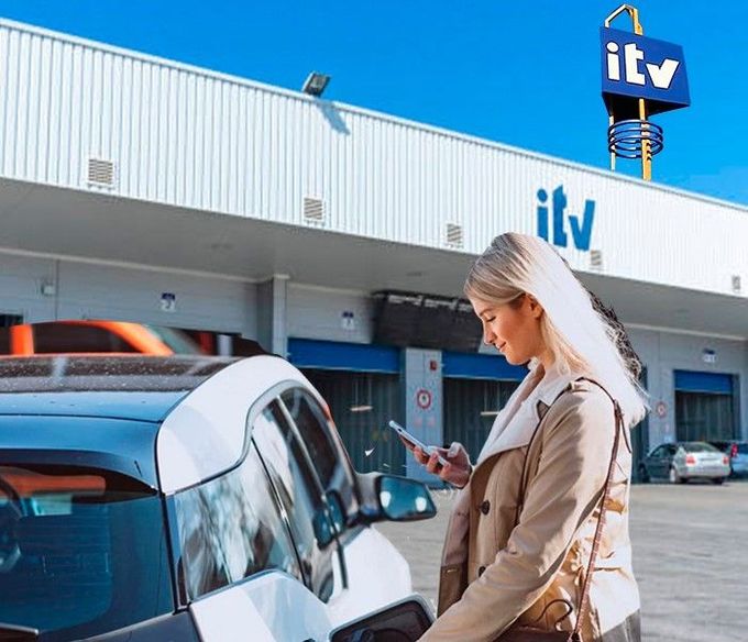 Una mujer está cargando su coche eléctrico y mirando su teléfono.