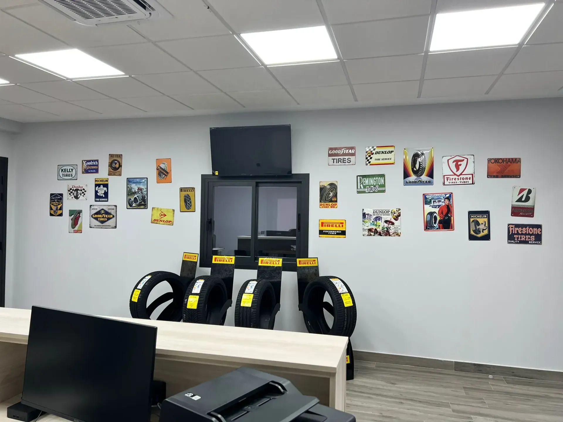 Neumáticos expuestos en una tienda, con un escaparate y un cartel que dice 