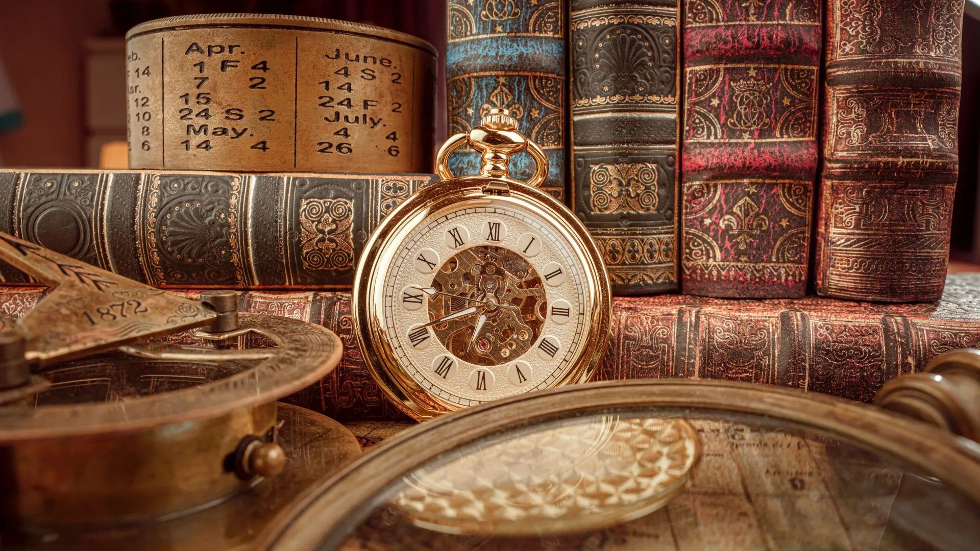 Livres anciens reliés avec une montre et un compas.