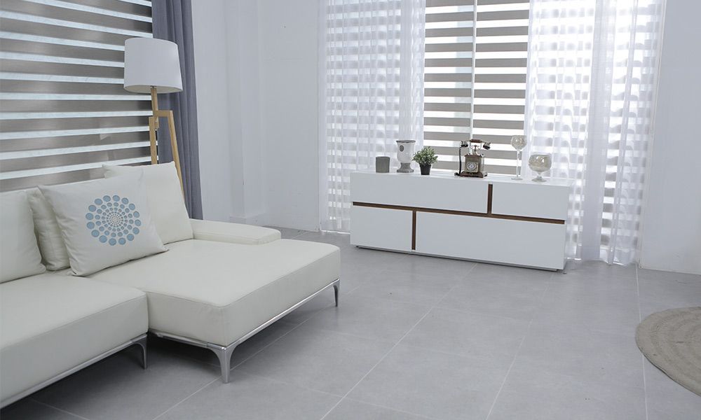 Salon avec canapé blanc, stores et console.