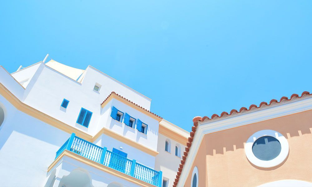 Bâtiments blancs et pêche avec des touches de bleu sur un ciel d'un bleu éclatant.
