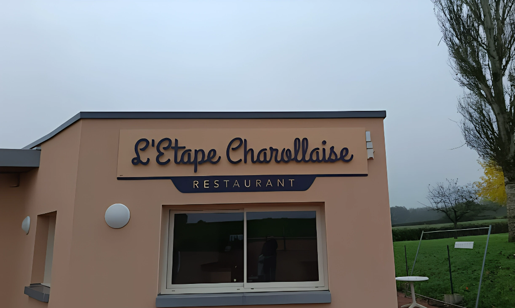 Enseigne du restaurant L'Étape Charollaise au-dessus d'une fenêtre d'un bâtiment couleur pêche.