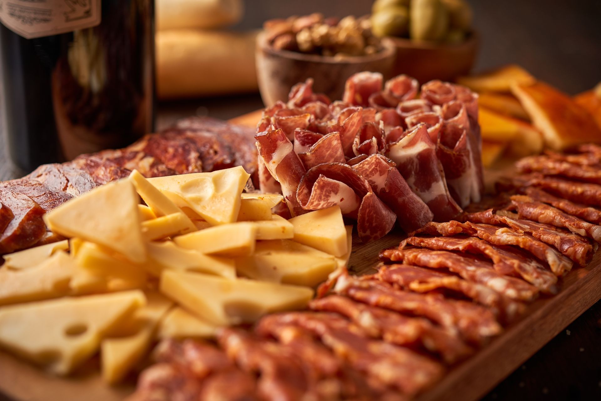 Planche de charcuterie avec fromages tranchés et charcuterie sur un plateau en bois