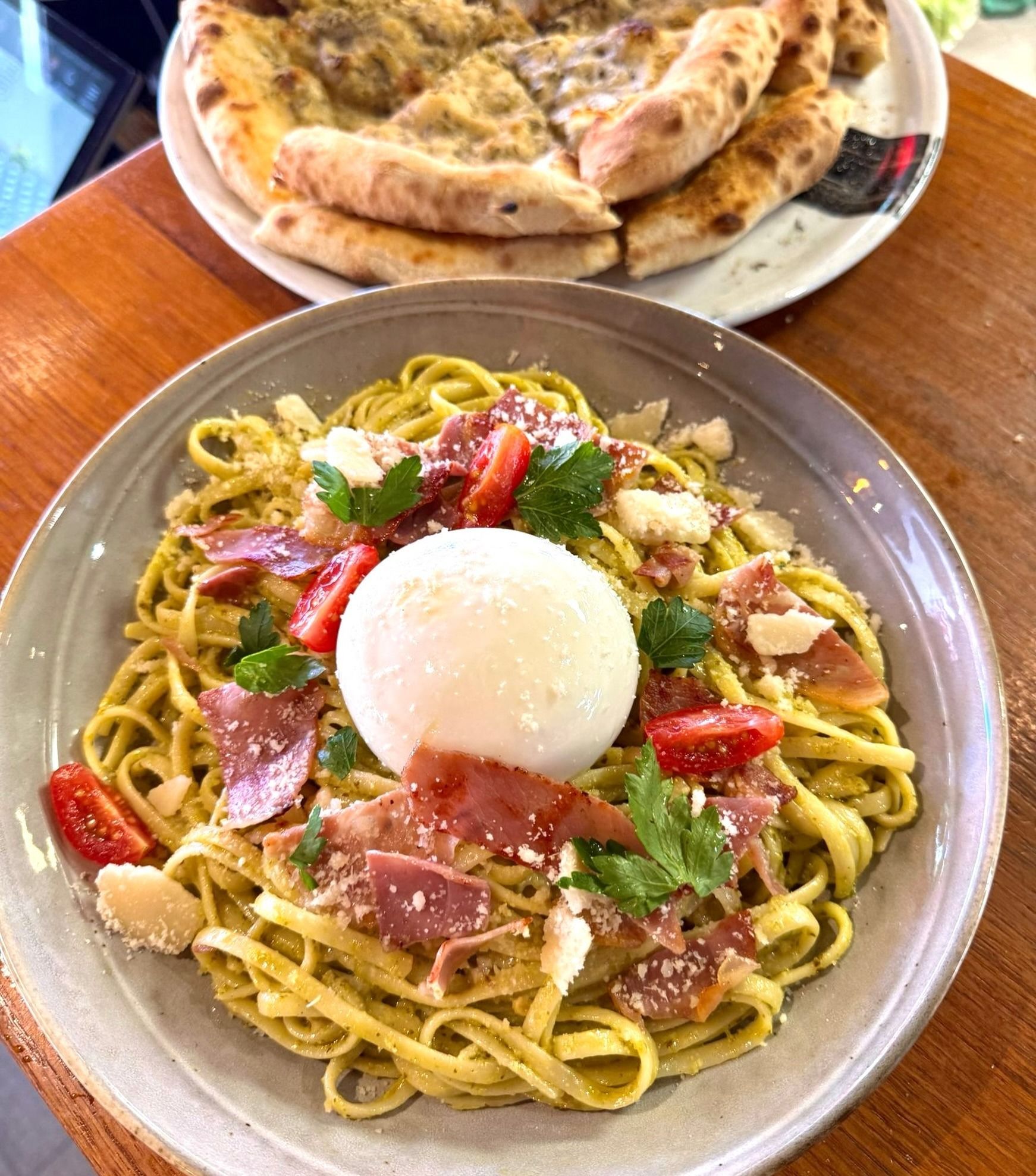 Assiette de spaghettis avec un œuf poché, du prosciutto, des tomates et des herbes