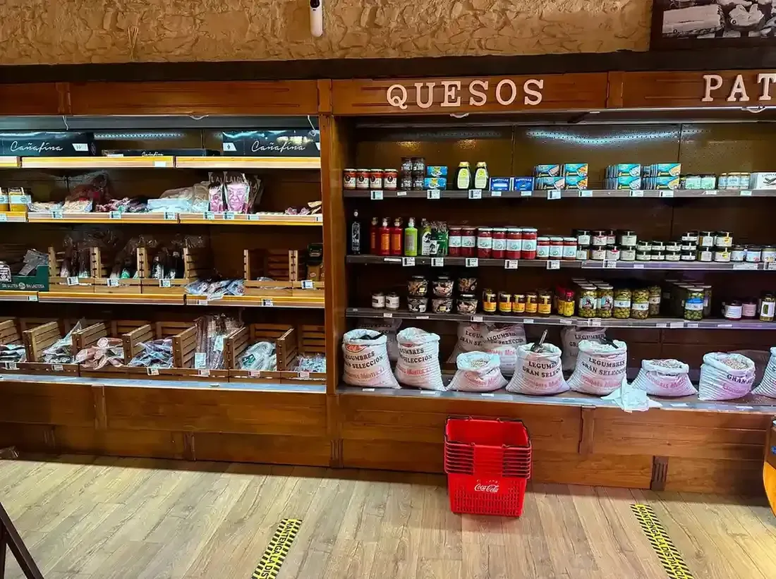 Vitrina de panadería con pasteles, bollería y dulces envasados ​​variados bajo cristal.