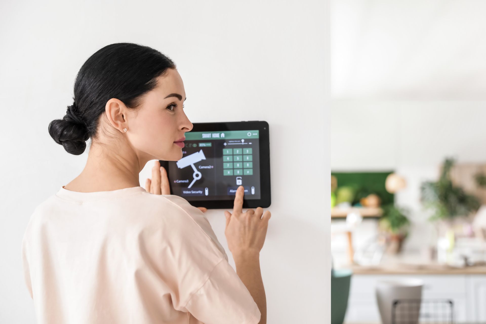 Una mujer está usando una tableta para controlar el sistema de seguridad de su hogar.