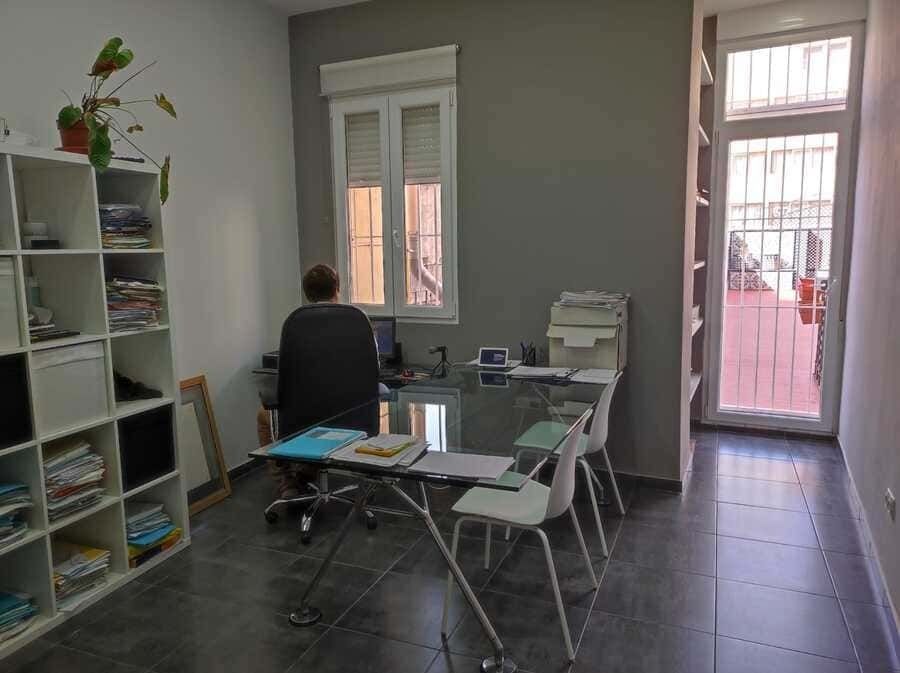 Un hombre está sentado en un escritorio en una oficina.