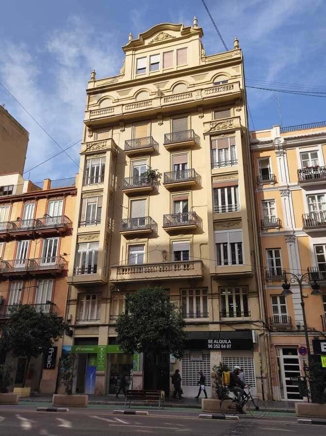 Un edificio grande con muchas ventanas y balcones.
