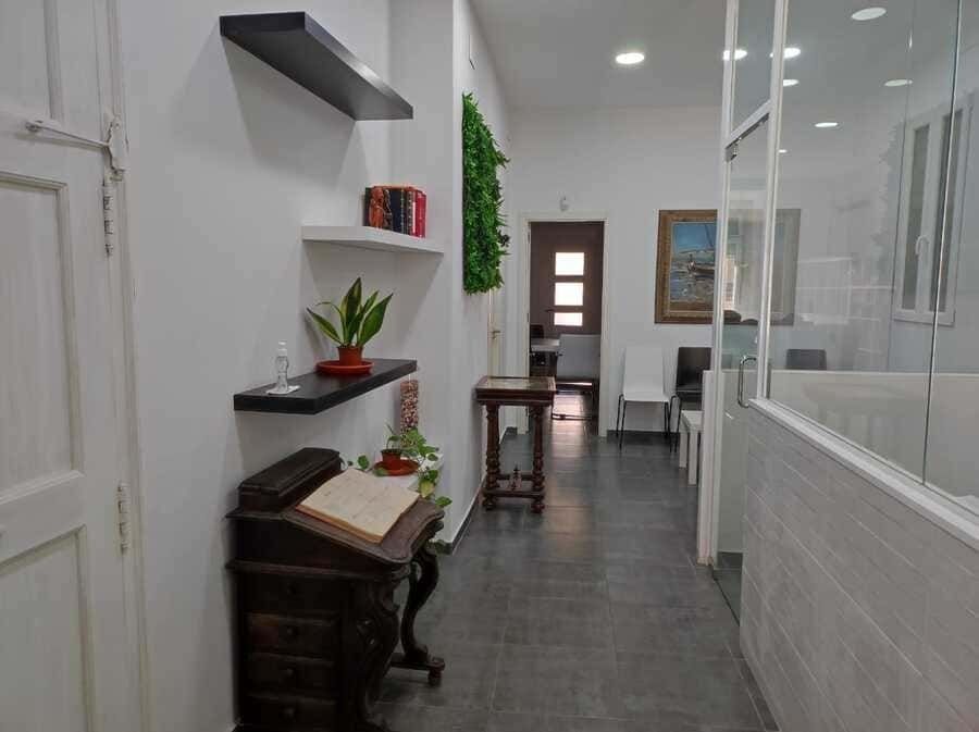 Un largo pasillo con un libro sobre un escritorio en el medio.