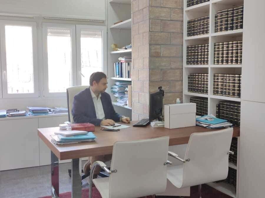 Un hombre está sentado en un escritorio frente a una computadora.