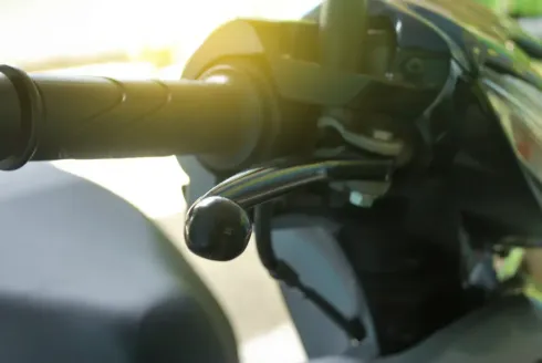 Palanca de freno de motocicleta negra, primer plano, al aire libre.