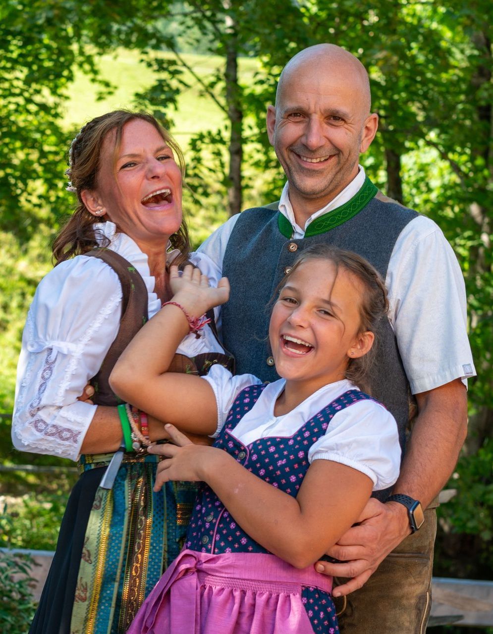 Eine Familie posiert gemeinsam in traditioneller Kleidung für ein Foto.