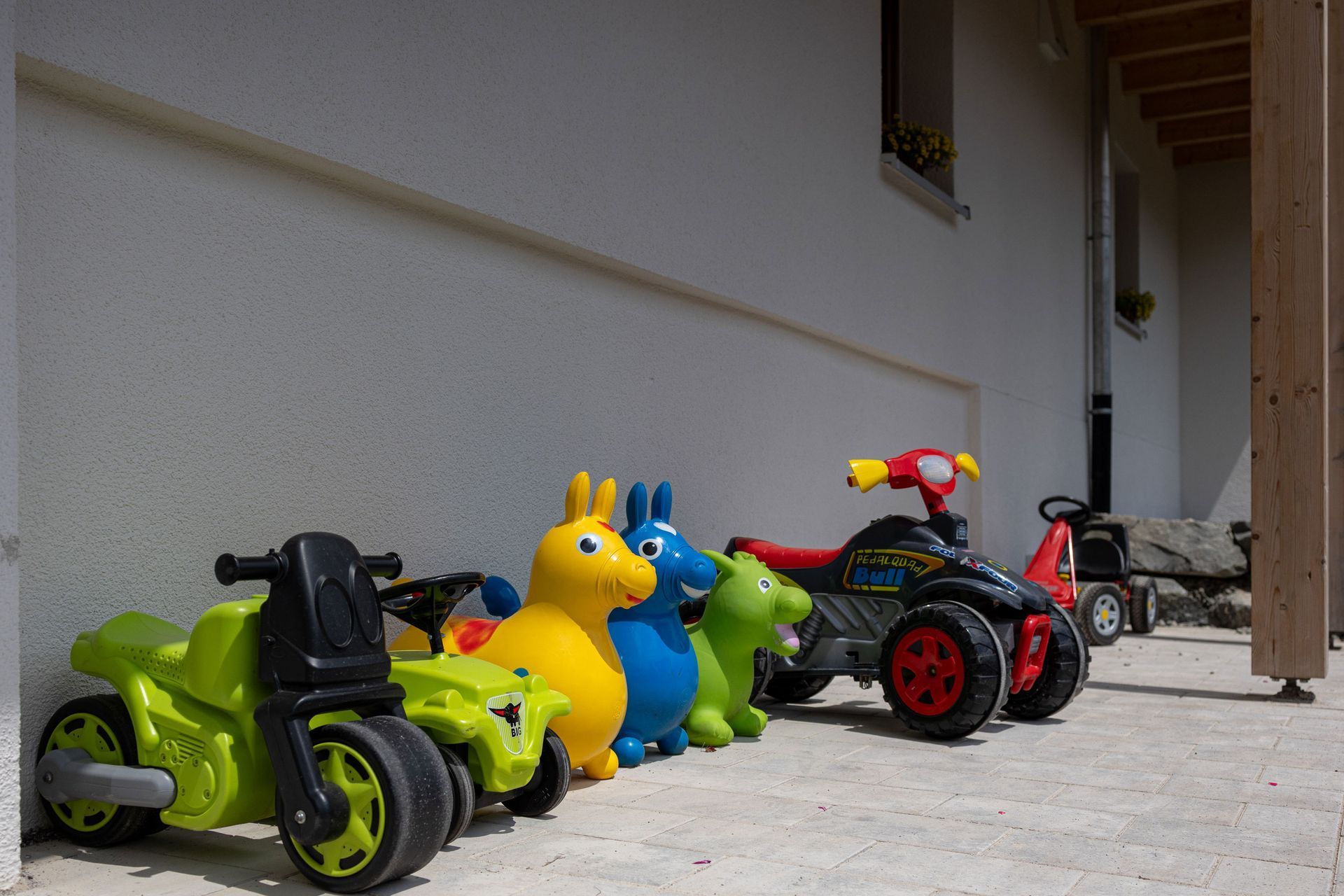 Vor einem Gebäude ist eine Reihe von Spielzeugautos geparkt.