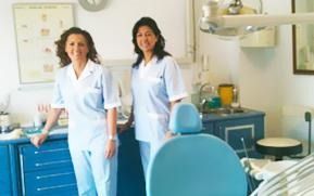 Dos dentistas mujeres están paradas una al lado de la otra en un consultorio dental.