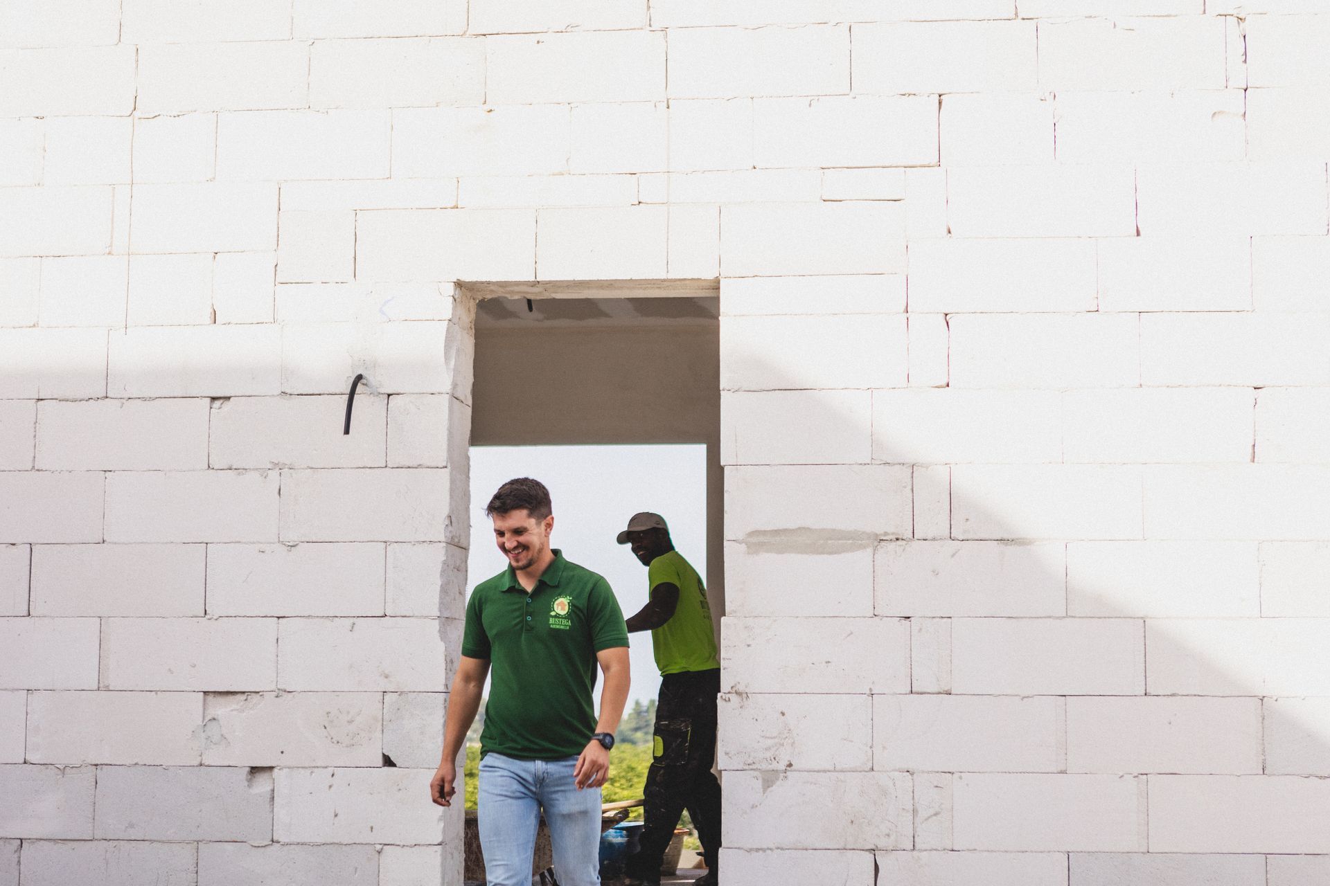 El hombre lleva una camisa verde y una chaqueta negra.