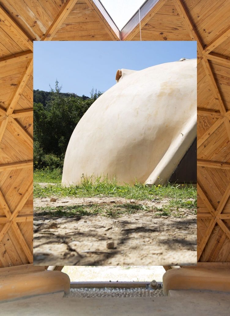 Un gran objeto blanco es visible a través de una ventana en una estructura de madera.
