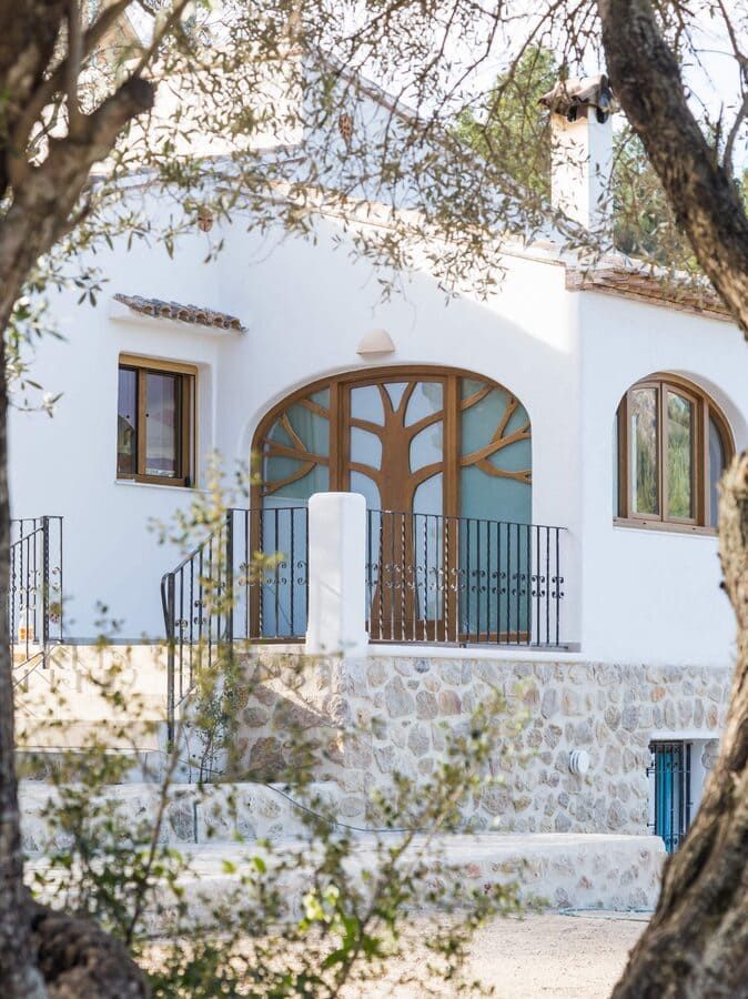 Una casa blanca con un diseño de árbol en la puerta de entrada.