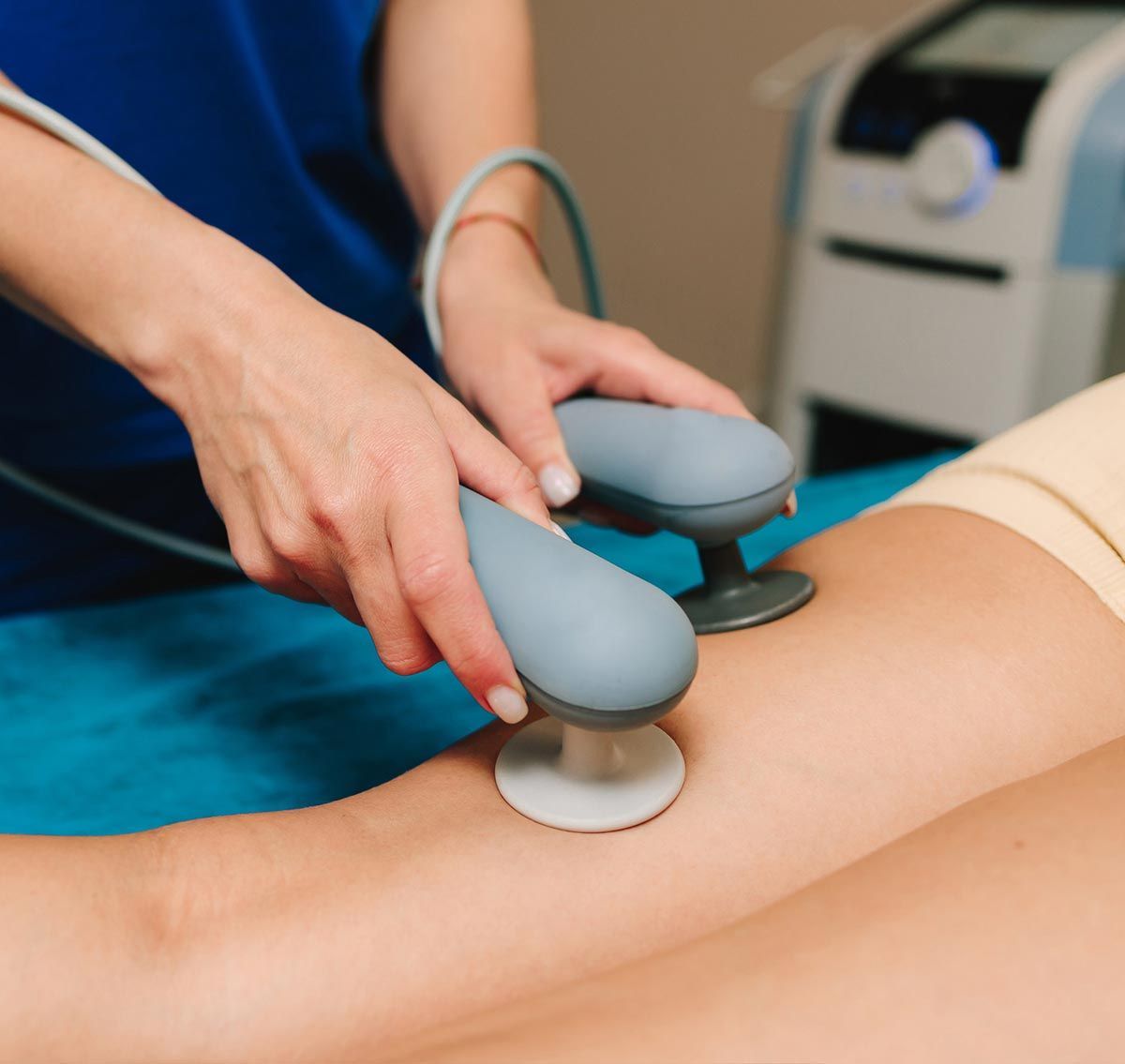 Persona recibiendo fisioterapia en la pierna con un dispositivo portátil.