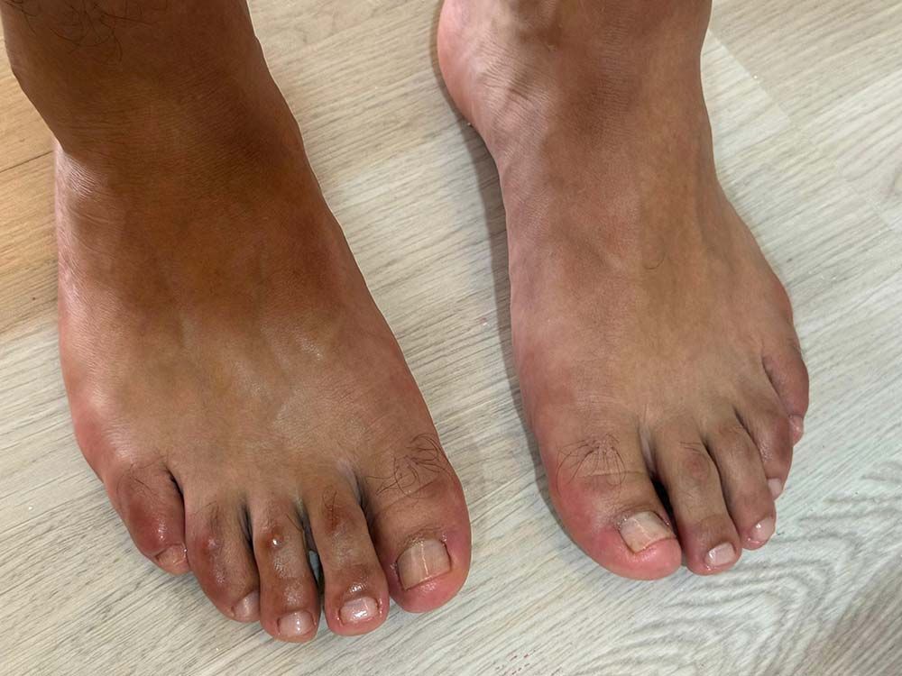 Dos pies descalzos, color piel, sobre un suelo de madera clara.