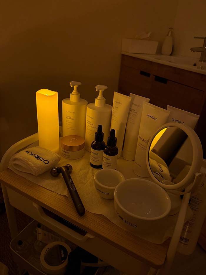 Productos y herramientas de belleza dispuestos en un carrito, iluminados por una cálida luz amarilla.