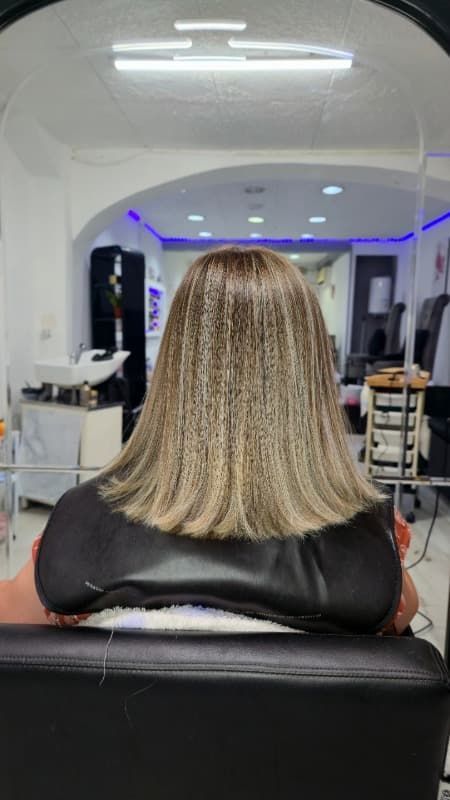 Una mujer está sentada en una silla en una peluquería.