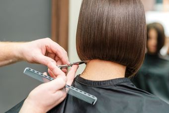 Una mujer se está cortando el pelo en una peluquería.