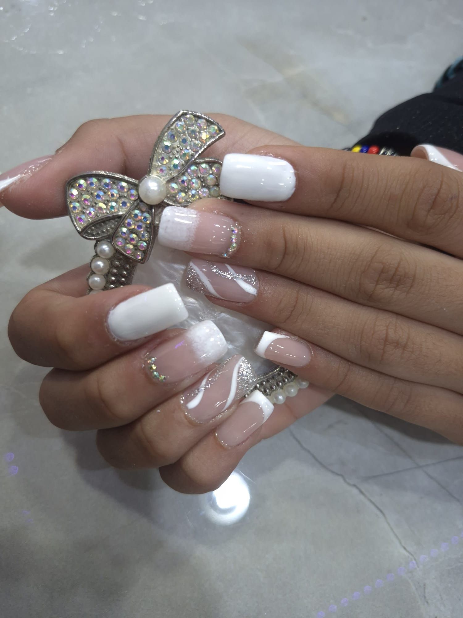 Un primer plano de las uñas de una persona con un lazo en ellas.
