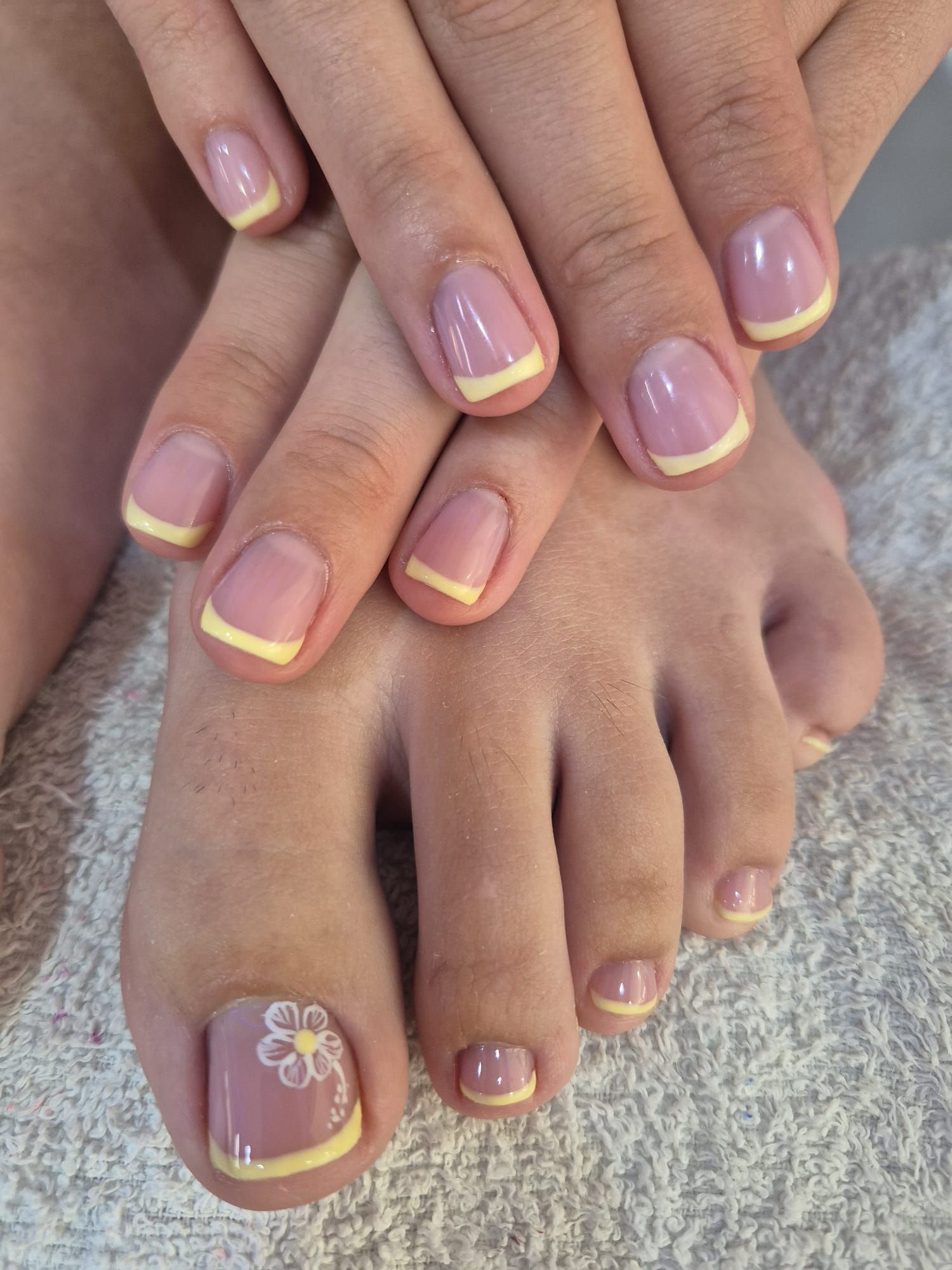 Un primer plano de las uñas de una mujer con un diseño floral.