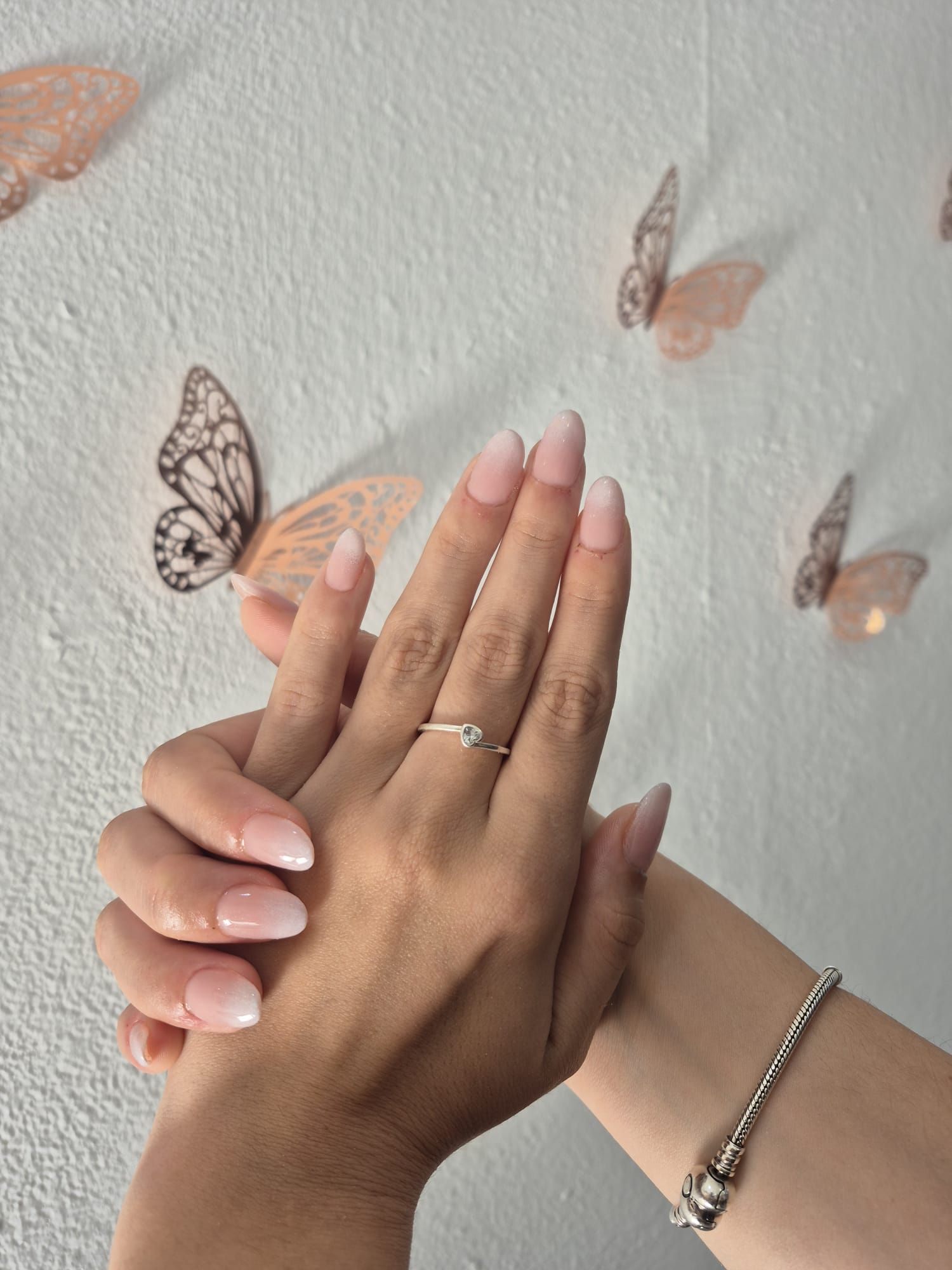 La mano de una mujer con un anillo y una pulsera.